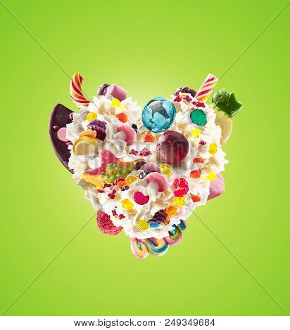 Milk Shake With Sweets And Whipped Cream, Heart Form Front View. Crazy Freakshake Food Trend. Front 