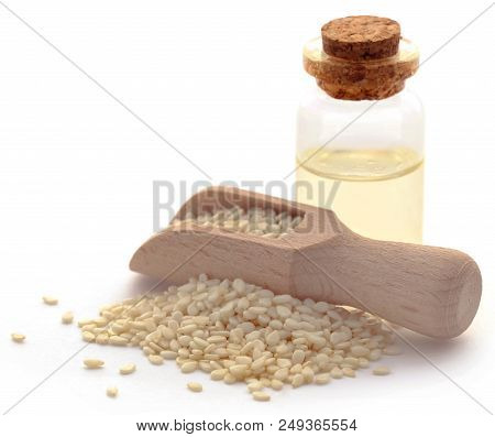 Peeled Sesame Seeds With Oil In A Bottle Over White Background