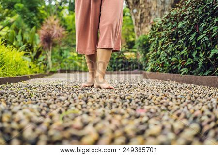 Woman Walking On A Textured Cobble Pavement, Reflexology. Pebble Stones On The Pavement For Foot Ref