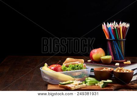 Concept Of School Lunch Break With Healthy Lunch Box Full Of Sandwiches, Banana, Apples And School S