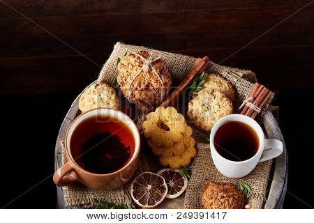 Cookies With Cinnamon And Two Cups Of Tea On A Burlap Napkin, Selective Focus, Close-up, Top View. D