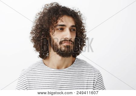Portrait Of Smart Deamy Attractive Bearded Man With Curly Hair, Looking Right While Thinking Or Spac