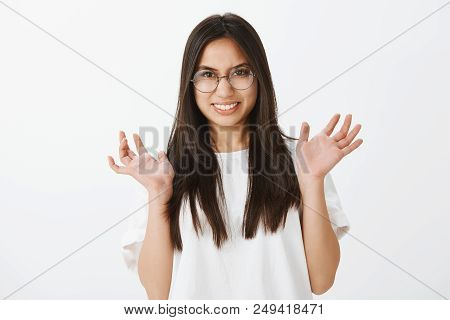 Waist-up Shot Of Disgusted Uncomfortable Intense Woman With Dark Hair, Raising Palms And Grimacing W