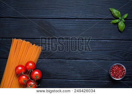 Tomato Organic Spaghetti With Fresh Cherries, Red Pepper In Little Glass Bowl And Basil Leaf On Blac