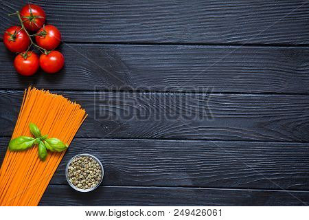Organic Spaghetti With Fresh Cherries, Red Pepper In Little Glass Bowl And Basil Leaf On Black Woode