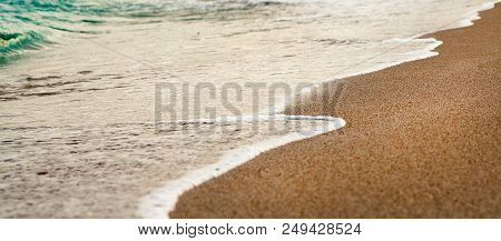 Waves Wash Over Golden Sand On Beach.