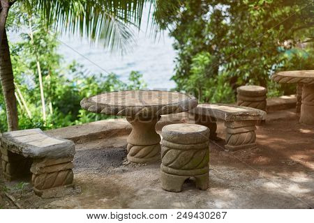 Empty Stone Table With Chairs In Green Prk Background