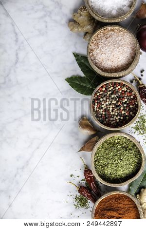 Set Of Spices On Rustic Murble Background. Coconut Shell Bowls With Paprika Salt Parsley And Pepper.
