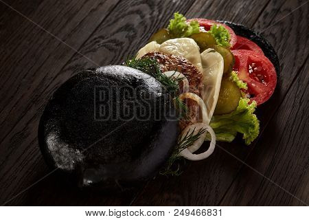Black Burger On Vintage Wooden Background, Top View, Close-up, Selective Focus. Artistic Layout. Exo