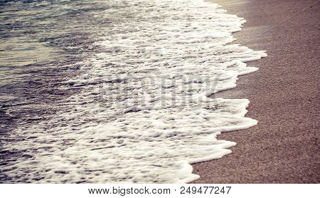 Waves Wash Over Golden Sand On Beach
