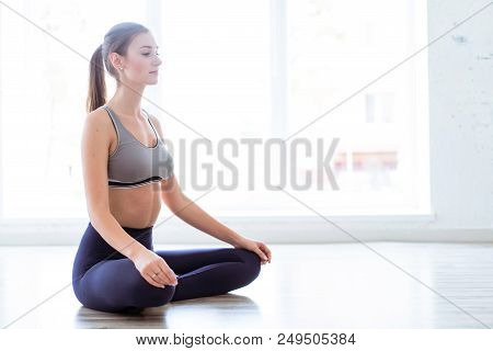 Photo Of A Young, Beautiful Woman, Doing Yoga And The Lotus Posity In The Studio, Beautiful And Heal