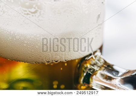 Close Up Of A Half-liter Glass Of Beer With Frothy Foam On Top.