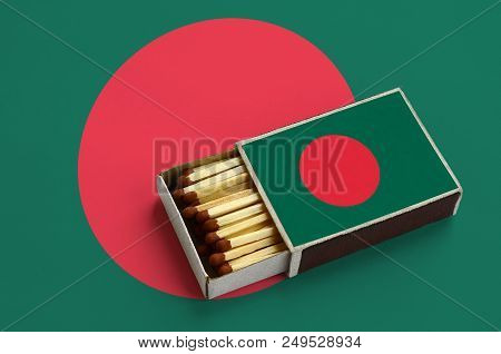 Bangladesh Flag  Is Shown In An Open Matchbox, Which Is Filled With Matches And Lies On A Large Flag