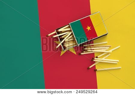 Cameroon Flag  Is Shown On An Open Matchbox, From Which Several Matches Fall And Lies On A Large Fla