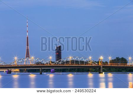 Riga, Latvia. Two Bridges Over Daugava Together: Stone Akmens And Railway Bridge In Evening Illumina