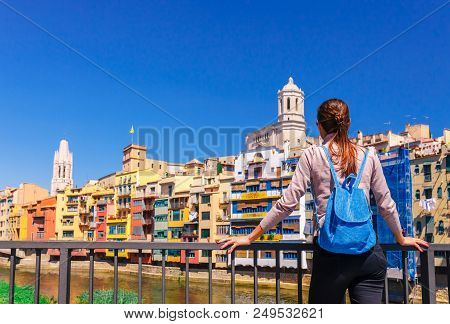 Tourist Woman See On Colorful Red And Yellow Houses And Bridge River Onyar In Girona, Catalonia, Spa
