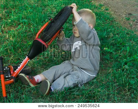 A Little Boy Dreams Of Becoming A Mechanic. The Guy Trains On A Bicycle. The Child Spins The Nuts On