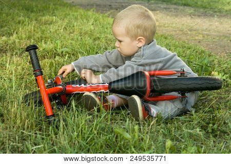 A Little Boy Dreams Of Becoming A Mechanic. The Guy Trains On A Bicycle. The Child Spins The Nuts On