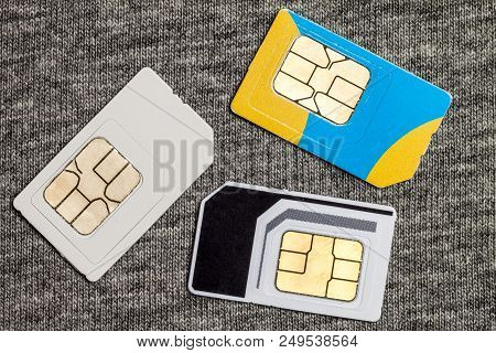 Set Of Mini, Micro And Nano Simcard. Isolated On Grey Cloth Texture Background