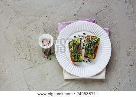 Healthy Vegan Breakfast Or Lunch On Plate Flat Lay. Avocado Toasts With Micro Greens Over Light Conc