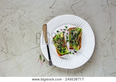 Healthy Vegan Breakfast Or Lunch Flat Lay. Fresh Avocado Toasts On Plate With Micro Greens Over Ligh