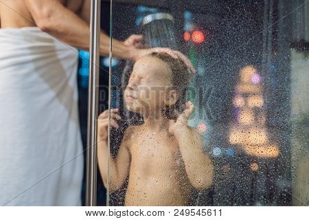 Dad Washes His Son's Hair In The Shower In The Evening Before Going To Sleep On The Background Of A 