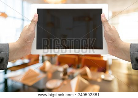 Abstrast Blurred background : restaurant cafe blur with bokeh with hand Hold digital tablet