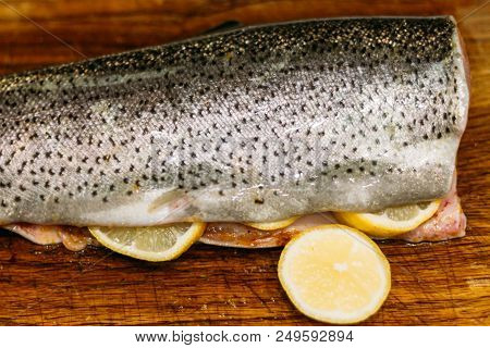 Raw Fish. Raw Fresh Salmon, Trout, On A Table On A Cutting Board. Kitchen. With Lemon Ready For Baki
