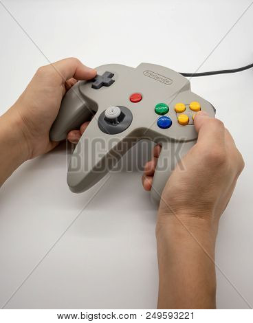 Nintendo64 : Bangkok, Thailand - July 12, 2018 : Hand Hodling The Grey Nintendo 64 Game Controller I