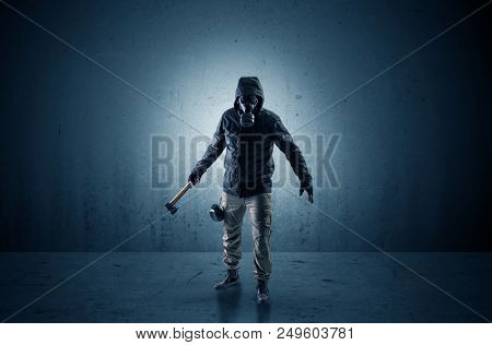 Bad agent in a dark room with arms on his hand and gas mask