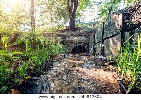 Old Concrete Drainage Pipes With Flowing Wastewater, Sewage Or Sewerage Tunnel Tube With Water Strea