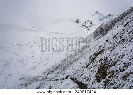 A Small Bridge On The Snow-covered Thorong La Pass On A Cloudy Day, Nepal.