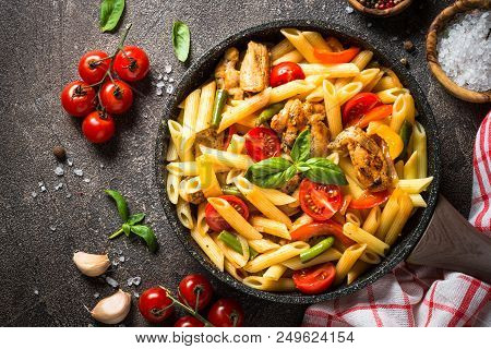 Pasta Penne With Chiken Meat And Vegetables. Top View On Dark Stone Background.