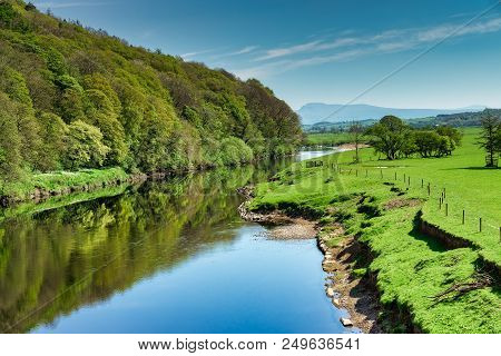 The River Lune Near Lancaster Flowing Through Lush Green Countryside With Ingleborough On The Far Ho