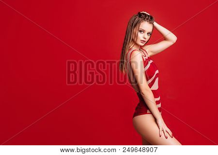 Pretty Bikini Model In Studio On Red Background