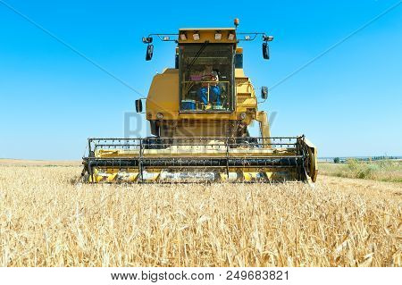 Harvester In The Foreground On Rustic Background Working In The Field