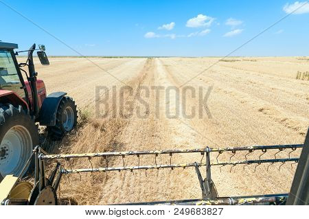 Harvester In The Foreground On Rustic Background Working In The Field
