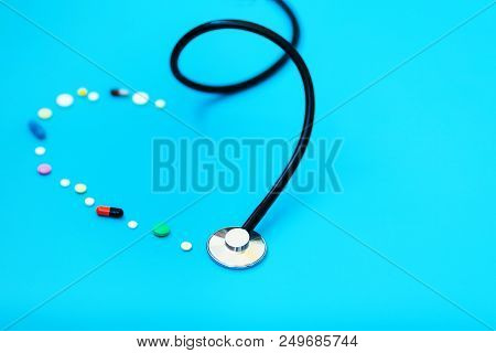 Medicine Stethoscope And Pills On Blue Background. Cardiology Heart Treatment.
