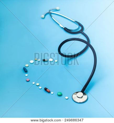 Medicine Stethoscope And Pills On Blue Background. Cardiology Heart Treatment.