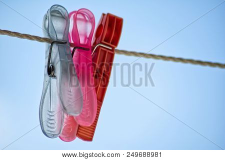 Colored Plastic Clothespins. Plastic Colored Laundry Linen On Laundry Linen In The Background Of Blu