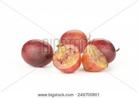 Group Of Three Whole Two Halves Of Fresh Red Gooseberry Hinnomaki Variety Isolated On White