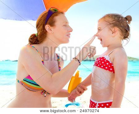 datter og mor i beach med solcreme i bikini