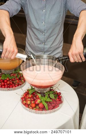 Beverage With Ice Cubes. Pouring Champagne. Mint And Fruit Are Out Of Focus