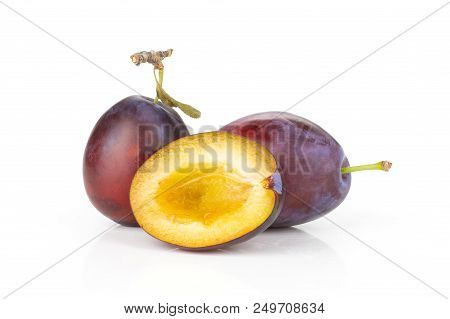 Group Of Two Whole One Half Of Fresh Violet-blue Plum Vibrant Moyer Variety Isolated On White