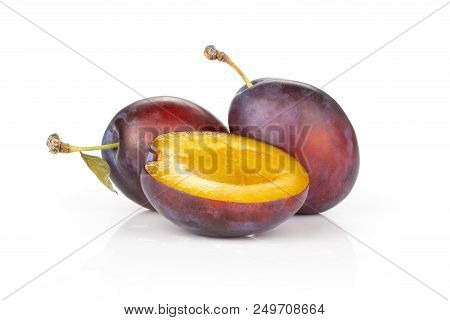 Group Of Two Whole One Half Of Fresh Violet-blue Plum Vibrant Moyer Variety Isolated On White