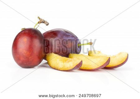 Group Of Two Whole Three Slices Of Fresh Violet-blue Plum Vibrant Moyer Variety Isolated On White
