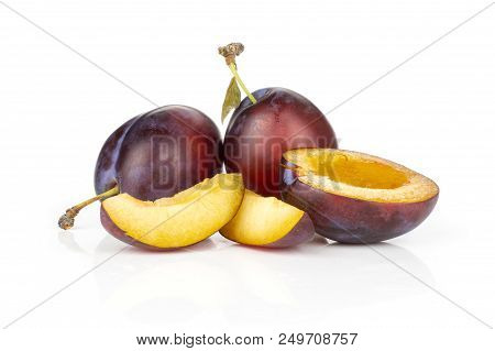 Group Of Two Whole One Half Two Slices Of Fresh Violet-blue Plum Vibrant Moyer Variety Isolated On W