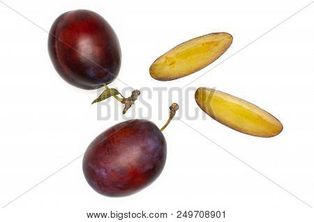 Group Of Two Whole Two Slices Of Fresh Violet-blue Plum Vibrant Moyer Variety Flatlay Isolated On Wh