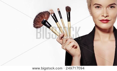Cosmetics And Beauty Treatment. Beautiful Girl With Make-up Brushes. Makeover. Makeup Artist Applyin