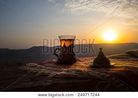 Arabian Tea In Glass On A Eastern Carpet. Eastern Tea Concept. Armudu Traditional Cup. Sunset Backgr